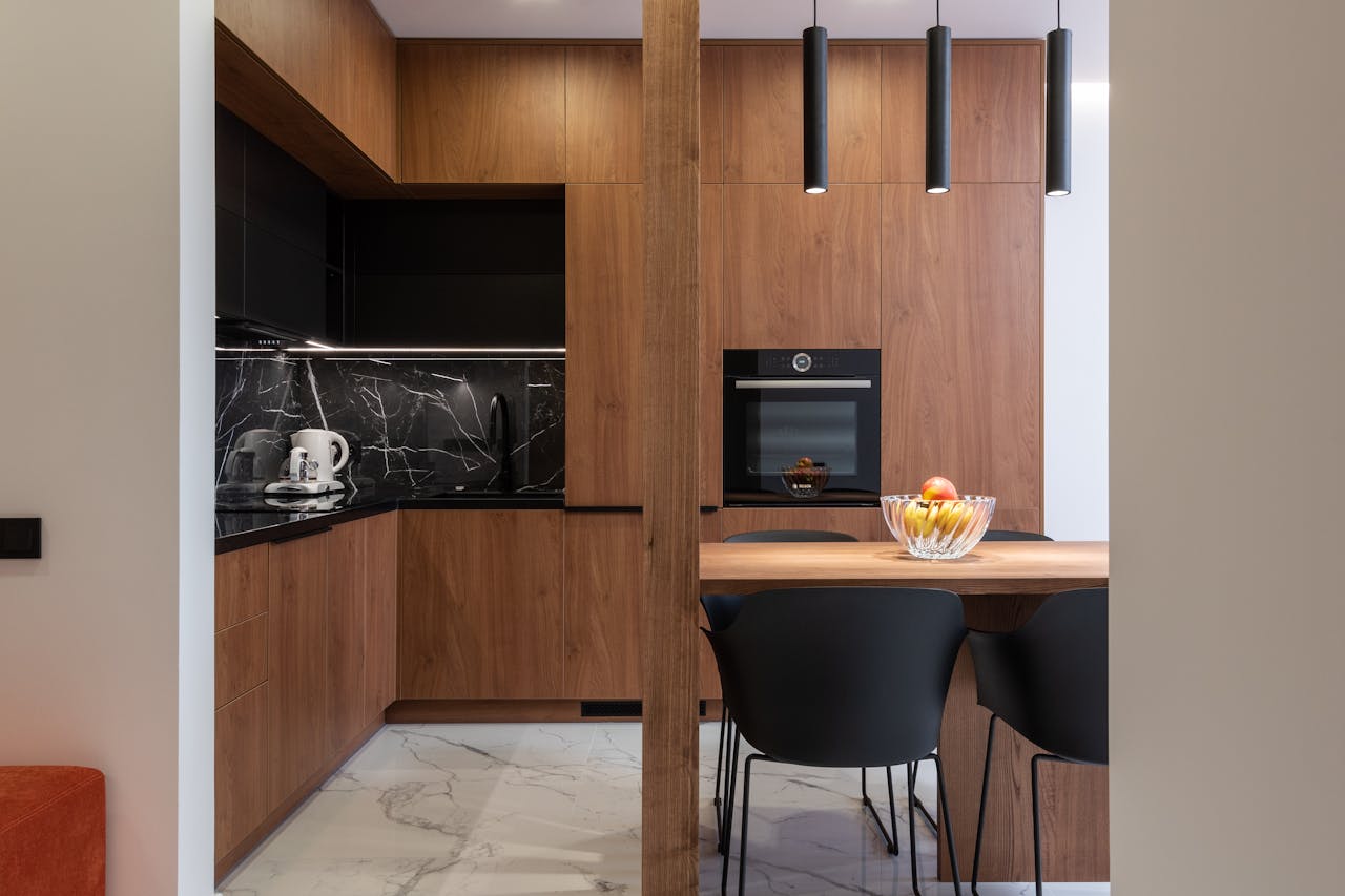 Sleek kitchen design featuring wooden cabinets, black accents, and modern appliances.